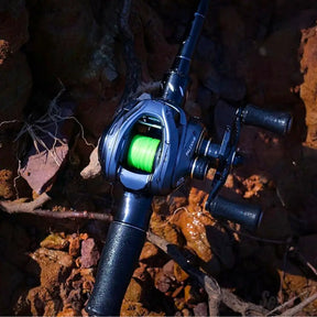 Carretilha SeaKnight FALCAN III com linha verde instalada posicionada sobre pedras molhadas